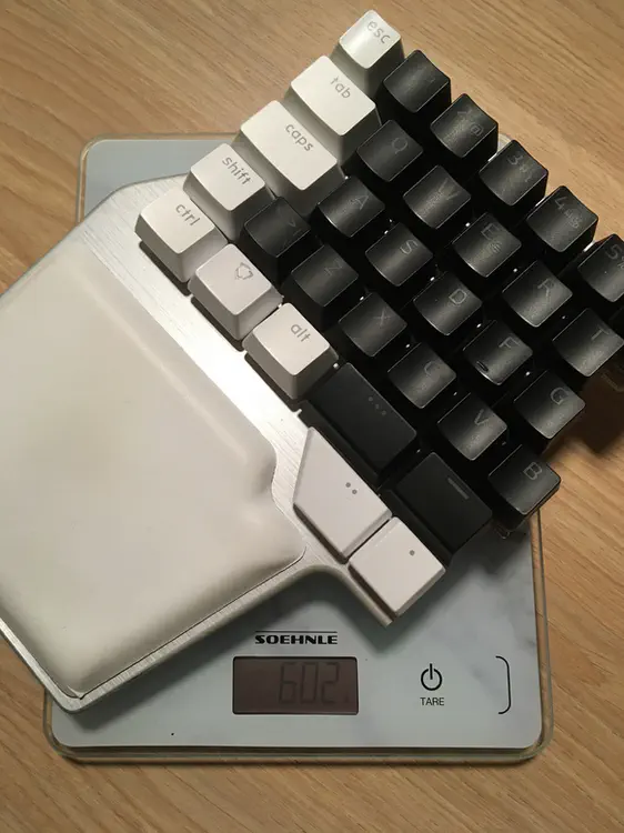 A photo of the left half of an ISO-layout Dygma Raise on top of a scale showing 602 grams.
