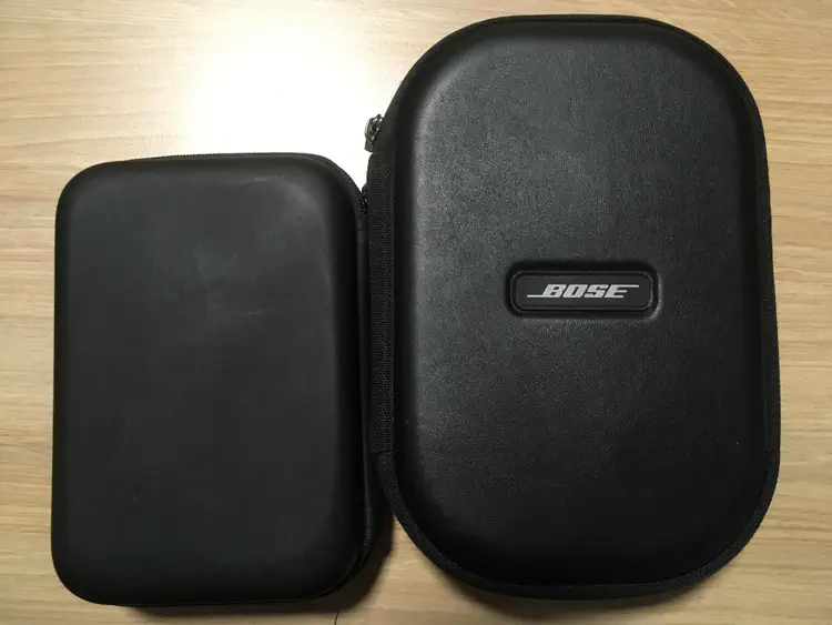 An image of the Zen's carrying case lying flat next to a Bose case. The Zen's case is about 4 cm shorter.