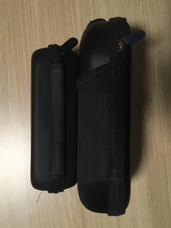An image of the Zen's carrying case lying on its side next to a Bose case. The Zen's case is about 4 cm shorter.